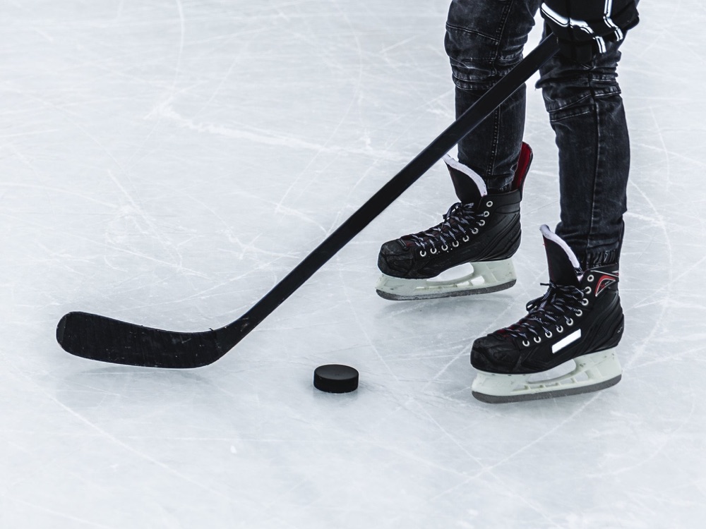 Hockey skates, a stick and a puck on the ice
